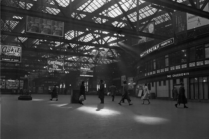 Morning sunshine filters through the roof at Glasgow Central Station where a number of recognisable features which still exist today can be seen. 