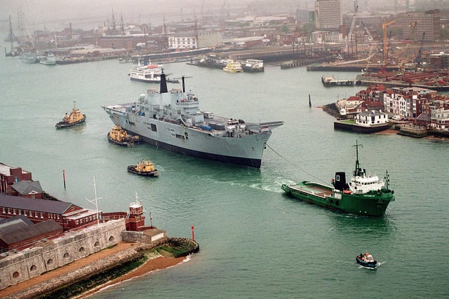 HMS Ark Royal being towed by tugs through the narrows, as she leaves Portsmouth Naval Base for Rosyth in 1999. Picture: Mike Scaddan 992149-2