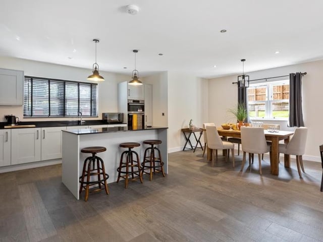 The kitchen, living room and dining room form one large open-plan area that sits at the heart of the Oakerthorpe property. This shot shows a stylish island-cum-breakfast-bar, plus a dining table. You would be able to choose the kitchen fittings and worktops from a range of standard and upgraded products.