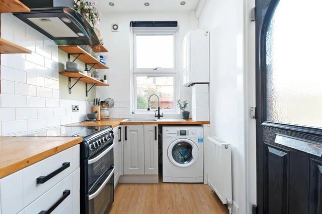 "Having a good range of fitted wall and base units with space for a cooker and plumbing and space for a washing machine," says the brochure. "Wood worktops with a stainless steel sink unit and drainer with mixer tap. Tiled splashbacks. Wall mounted combination boiler."
