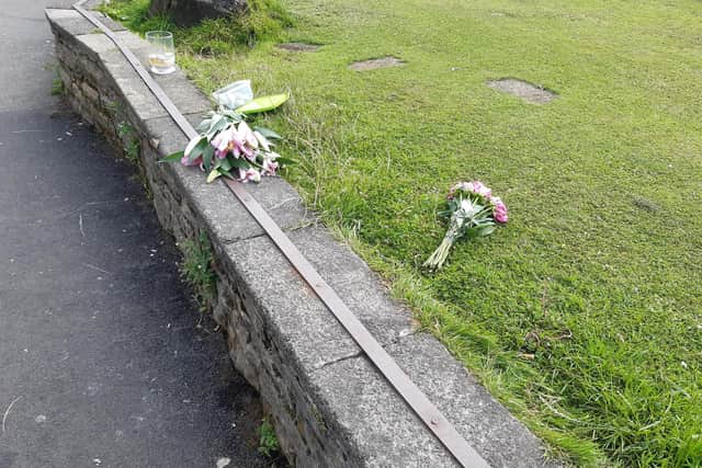 Candles and flowers in tribute to the man who died in Crookes Valley Lake by the side of the water