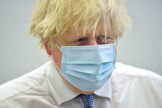 British Prime Minister Boris Johnson visits the Stowe vaccination centre in central London on December 13, 2021.  Johnson warned of a looming "tidal wave" of Omicron, and brought forward a target to give over-18s a booster jab by one month to the end of December.(Photo by JEREMY SELWYN/POOL/AFP via Getty Images)