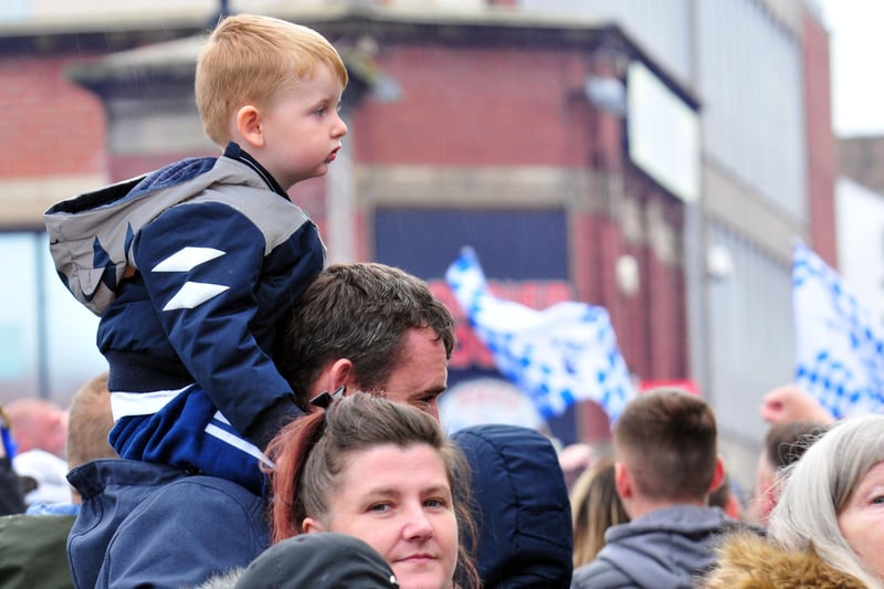 A young fan waits to see the parade bus arrive.