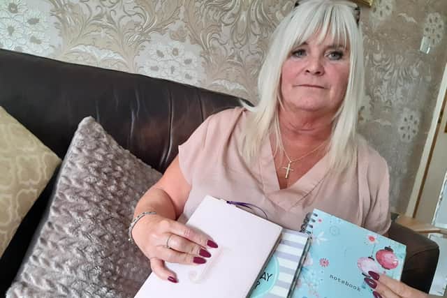 June Lowe is urging people to get any heart disease symptoms checked out so others do not have to go through what she did in November 2016, when her husband, Dave, suffered a heart attack diving at the Great Barrier Reef. She is pictured with diaries she hopes to turn into a book.
