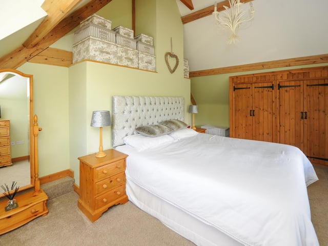 This room has vaulted ceilings and fitted wardrobes.