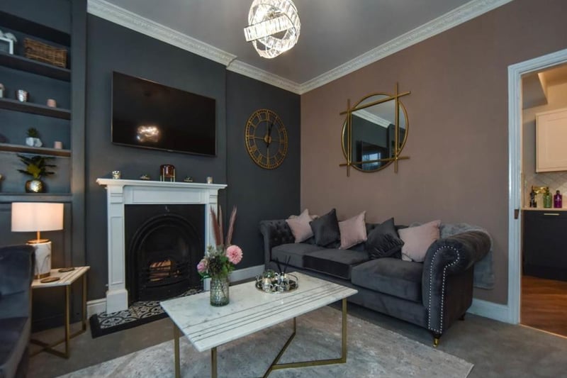 Front-facing, furnished in soft colours with the fireplace being the main focus.