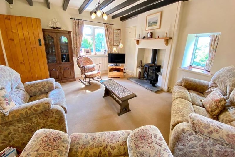 The sitting room is described as a "warm and inviting room" with a good level of natural light from uPVC double glazed windows to three elevations.