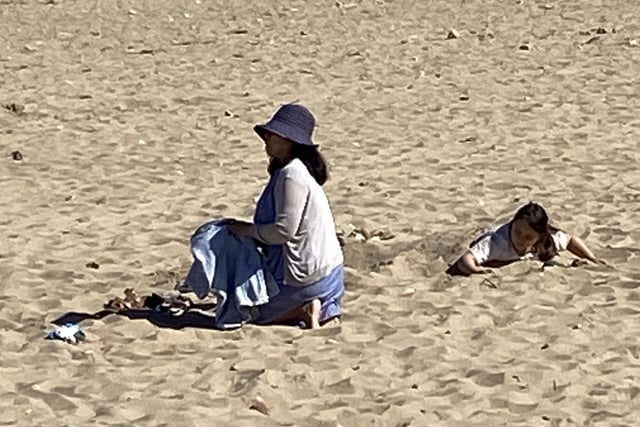 One beach-goer keeps covered up in the sun.