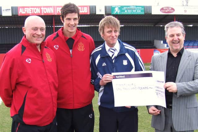 Alfreton Town present a cheque for £1,000 for the services of Pinxton FC youngster Aden Flint.