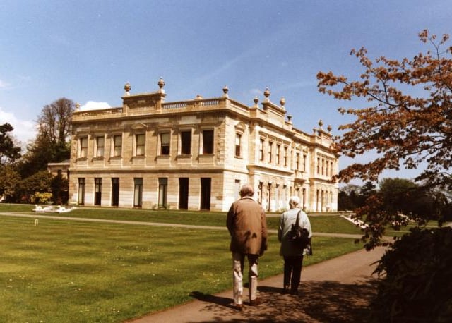 A couple walk around the grounds of the hall.