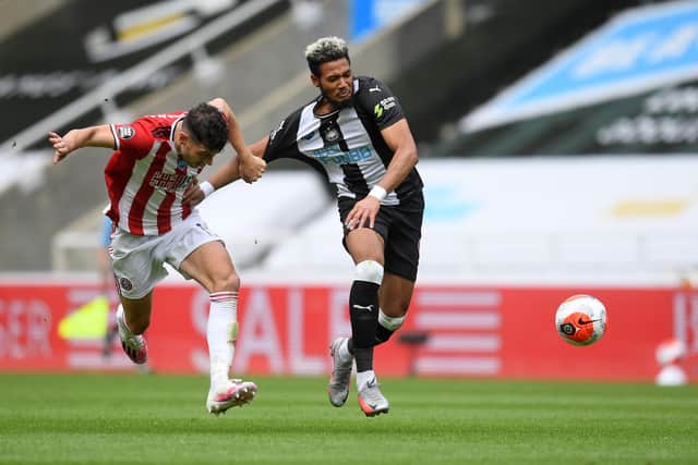 Sheffield United's  John Egan (L) fouls Newcastle United's Brazilian striker Joelinton (C) resulting in a second yellow card during the English Premier League football match at St James' Park (Photo by MICHAEL REGAN/POOL/AFP via Getty Images)