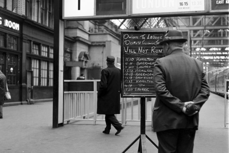 Passengers check the non-availability of trains on the notice board at Glasgow Central during the strike of June 1967. 