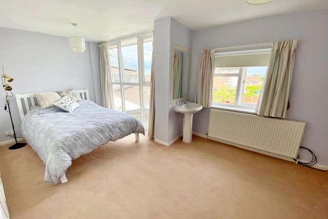This bedroom is wonderful due to it's large windows giving it a lot of natural light.