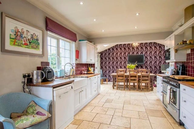 The open plan dining kitchen has limestone floor tiles and a Belfast sink.