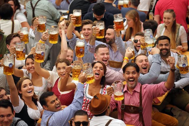 Revelers cheer with 1-liter-mugs of beer during the opening weekend of the 2019 Oktoberfest on September 21, 2019 in Munich, Germany. (Photo by Johannes Simon/Getty Images)