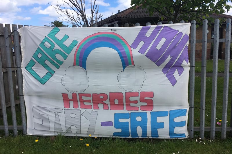 A home-made banner draped on a care home fence.