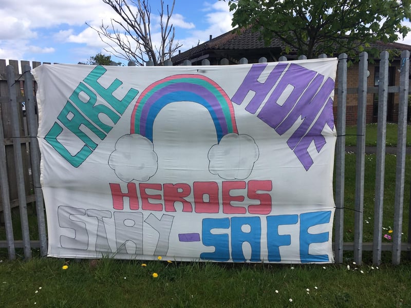A home-made banner draped on a care home fence.