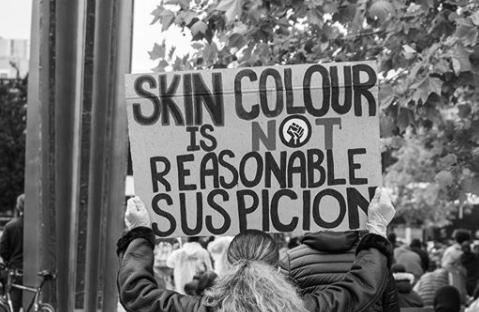 Sign reads: "Skin colour is not reasonable suspicion."