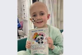 Heidi Howson proudly holding her bravery certificate during a hospital stay. She has received treatment at Sheffield Children's Hospital during a battle with leukaemia