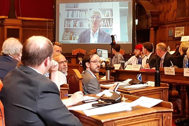 Councillors watch on screens as Sir Mark Lowcock speaks about his report into the street trees scandal at an extraordinary meeting of Sheffield City Council