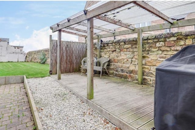 The back of the property also features a decking area and a log cabin.