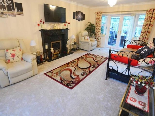 The first reception room is this lovely lounge, which offers a generous amount of space for furniture. It also boasts a feature fireplace, with decorative surround, carpeted floor, a window to the front of the house and French doors that open into the kitchen.