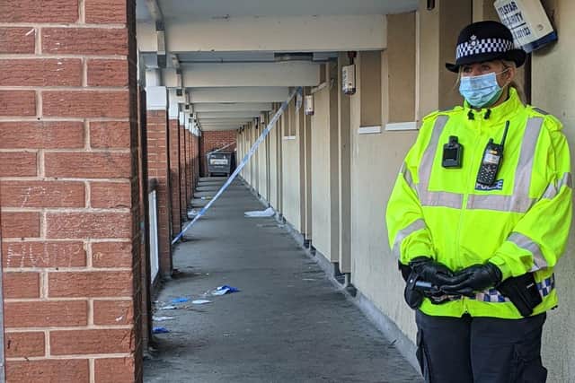 A police officer outside the flats on Club Garden Road, where a murder investigation has been launched. Photo: Steve Jones.