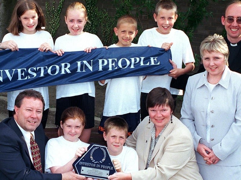 The St Aidan's R.C Primary School, Holmes House Avenue, Winstanley, have beeen awarded 'The Investor in People Award'. Della Bartle from The Wigan Borough Partnership presented the ward to pupils Alex Riley and Kate Williams with headmaster Gary Senior, left, watched by Christine Mason, right, Deputy head and pupils back row Kerry Barker Natalie Shaw Jamie Roberts and Thomas O'Brien and Father Mark Worden Chairman of Governors.