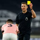 English referee Robert Jones shows a yellow card to Sheffield United's Irish defender Enda Stevens. (Photo by JASON CAIRNDUFF/POOL/AFP via Getty Images)
