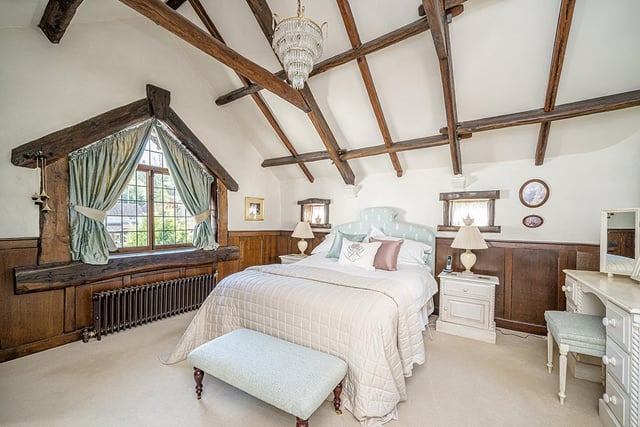 The first floor is accessed via a staircase with a porthole window, leading to a galleried landing with the master bedroom, which boasts vaulted ceilings with open trusses, and a large balcony.