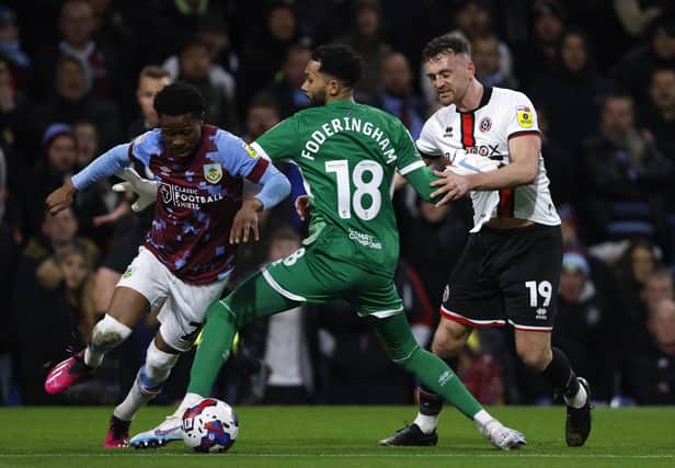 Sheffield United goalkeeper Wes Foderingham fouls Burnley's Nathan Tella (left) during the Sky Bet Championship match at Turf Moor, Burnley: Richard Sellers/PA Wire