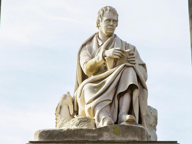 Beneath which monument would you find this fine statue? An extra point if you can identify the man and his dog.