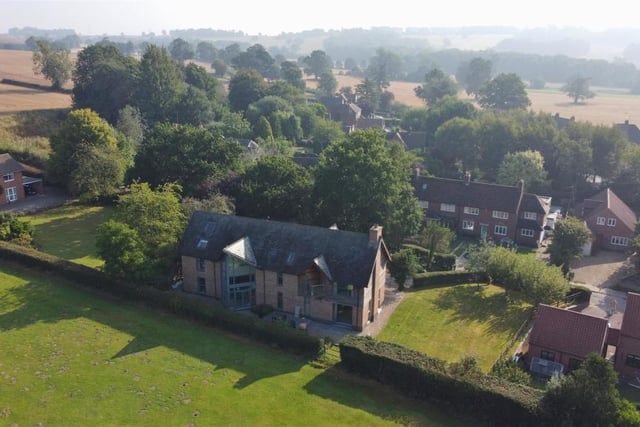 A spectacular aerial shot of the £1 million property. As you can see, to the side, there is a large lawn, bordered by flowerbeds and mature trees.The south-facing sun-terrace is also perfect for entertaining.