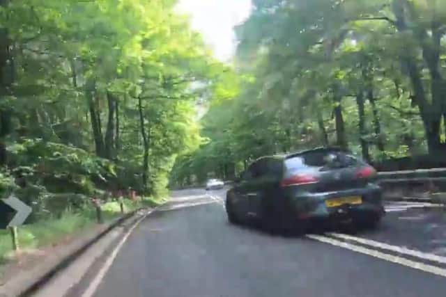 A driver crosses solid white lines to overtake a cyclist on the A57 in Sheffield, narrowly missing an oncoming car in the process (pic: @sheffbicycle)