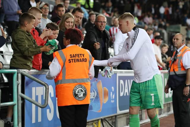 Aaron Ramsdale of Sheffield United hands over his gloves and shirt to young fans after the game at Swansea: Simon Bellis / Sportimage