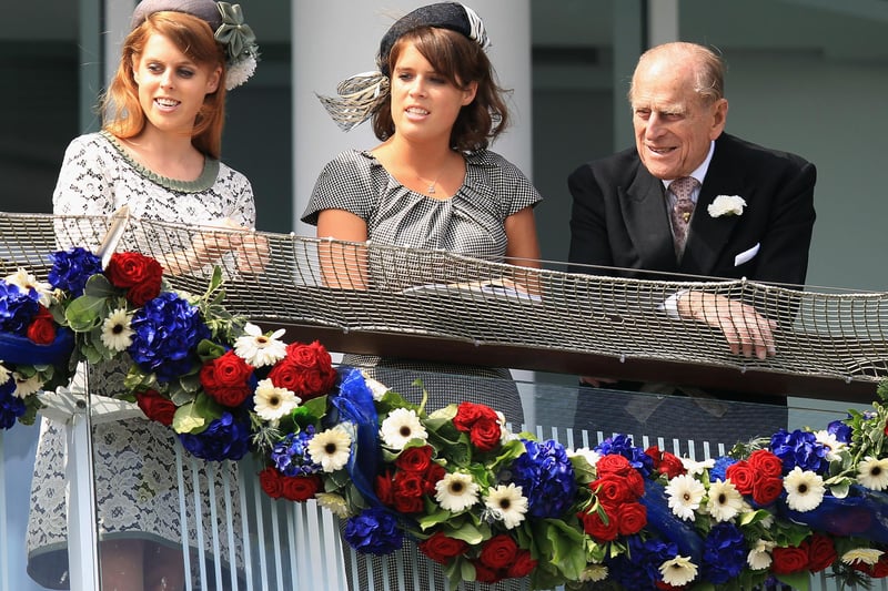 Princess Beatrice of York (left), Princess Eugenie of York and Prince Philip, Duke of Edinburgh watch the action from the royal balcony during the Epsom Derby, at the start of the weekend marking the Queen's Diamond Jubilee celebrations in 2012. (Photo by Bryn Lennon/Getty Images)