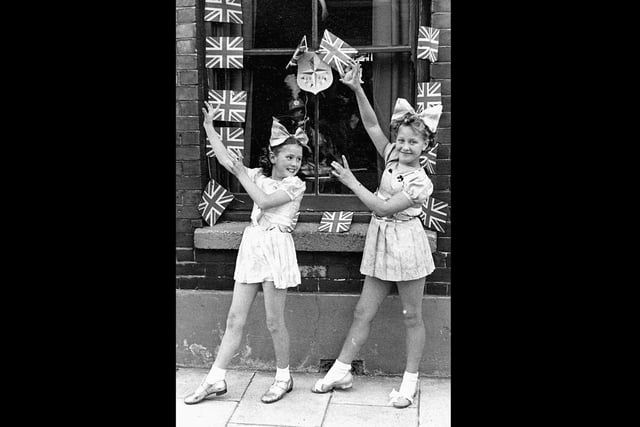 Festival of Britain street tea outside 14, Moorland Road Buckland Portsmouth. Kay Britno 9yrs on left & friend from Madame Selwood's dance troop outside her grandparents house entertaining the neighbours at a Festival of Britain street party in 1951