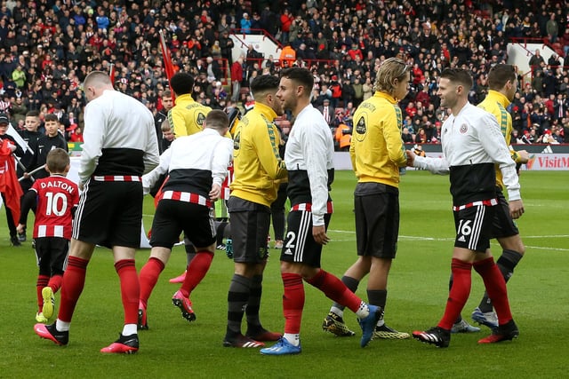 Players of Sheffield United and Norwich City give each other a fist bump instead of a hand shake prior to the Premier League match between Sheffield United and Norwich City at Bramall Lane on March 07. (Photo by Nigel Roddis/Getty Images)