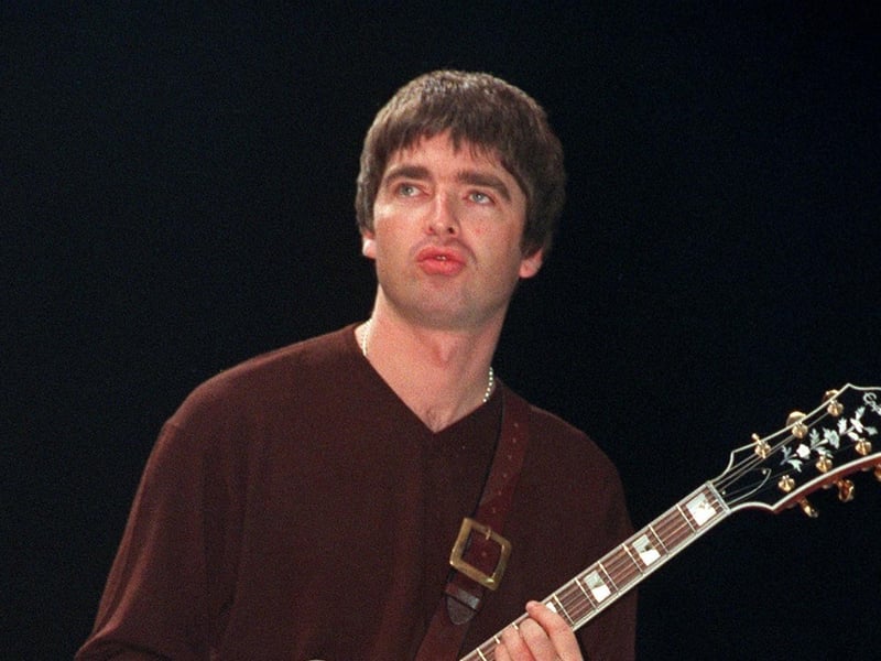 Noel Gallagher looks across to brother Liam as Oasis perform at Sheffield Arena in 1997. Photo: Dean Atkins