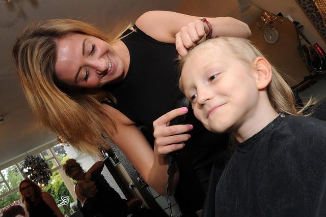 Draven Maclachlan, eight, has his hair cut off by Annelise Johnson, of Goldilocks Hairdressers for the Little Princess Trust in 2014