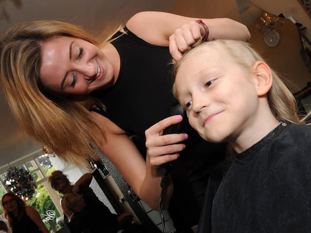Draven Maclachlan, eight, has his hair cut off by Annelise Johnson, of Goldilocks Hairdressers for the Little Princess Trust in 2014