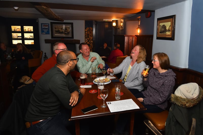 People enjoy a drink and food at The Old Sun Inn pub in Buxton. (Photo by Nathan Stirk/Getty Images)