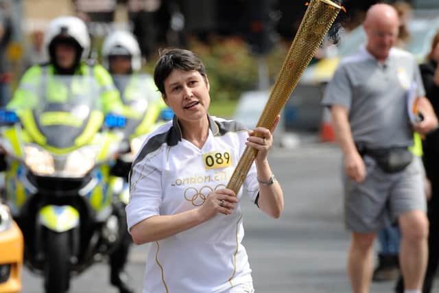 Torchbearer 089 Vikki Orvice carries the Olympic Flame on the Torch Relay leg between Barnsley and Kexbrough