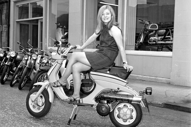 A model wearing a mini-dress poses on a Lambretta scooter outside the showroom of Graeme P Chatham in Edinburgh