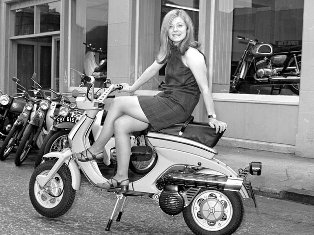 A model wearing a mini-dress poses on a Lambretta scooter outside the showroom of Graeme P Chatham in Edinburgh