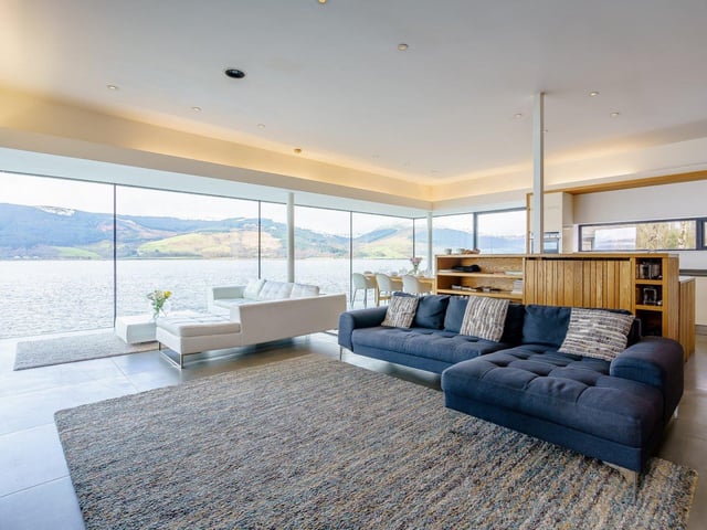 The floor to ceiling windows in the open-plan living space overlook the private beach.