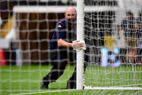 A member of ground staff disinfects the goal posts at half time during the Premier League match between Aston Villa and Sheffield United at Villa Park on June 17, 2020 in Birmingham, England. (Photo by Shaun Botterill/Getty Images)