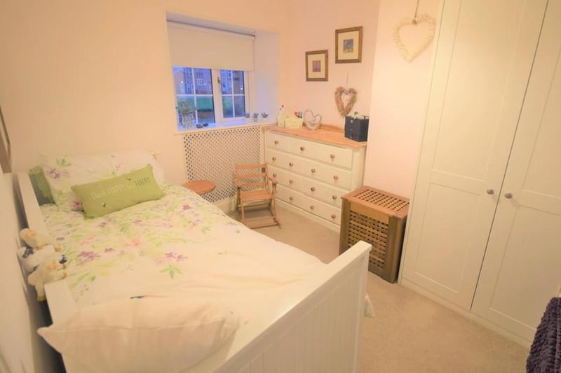 A front facing bright bedroom having a radiator with feature cover, fitted Sharpes wardrobes, and a lovely standard of internal decoration.
