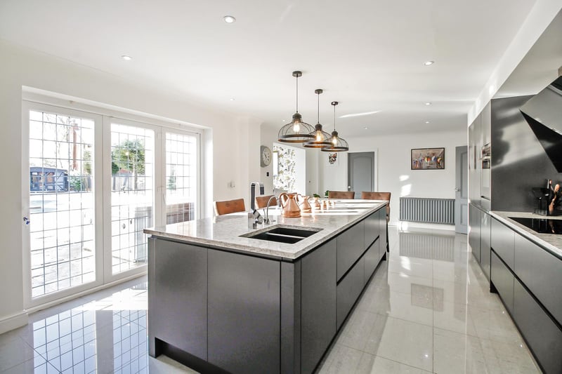 The beautiful and spacious kitchen boasts bi-fold doors, and a convenient breakfast island.