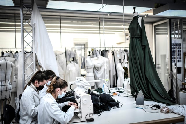 Seamstresses work on couture garments